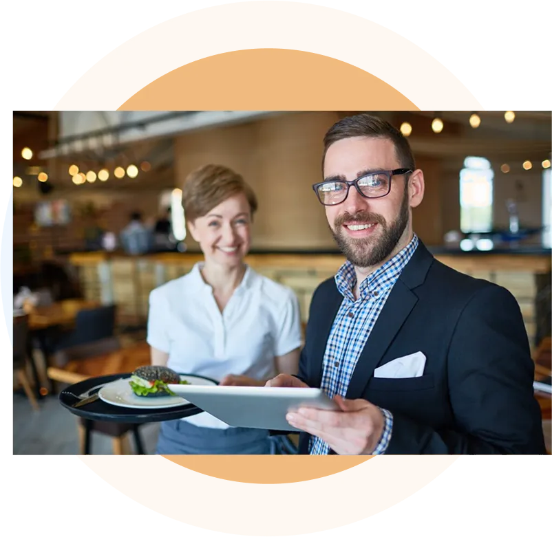 A restaurant owner and a Fit Health advisor reviewing plans on a tablet